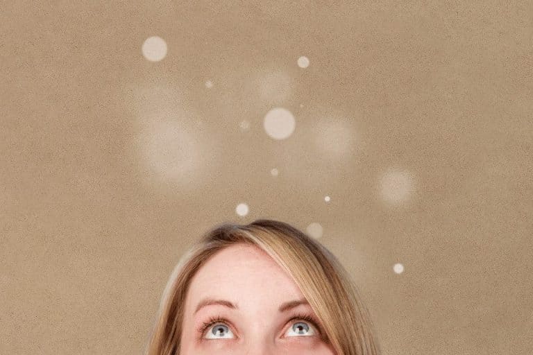 Eine Frau, die nach oben schaut und kleine Lichter sieht.